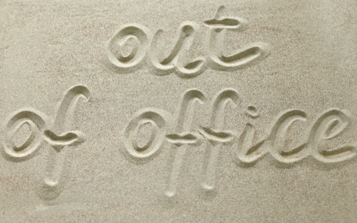 "out of office" written in sand